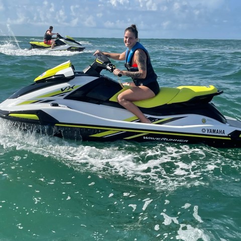 a man riding on the back of a boat in the ocean