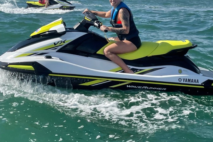 a man riding on the back of a boat in the ocean