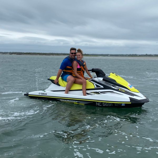 a man riding on the back of a boat in a body of water