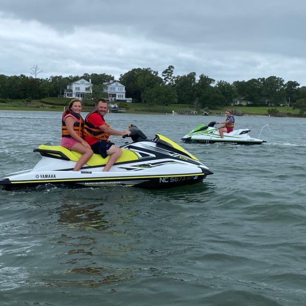 a group of people riding on the back of a boat in the water