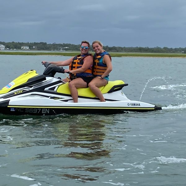 a person riding on the back of a boat on a body of water