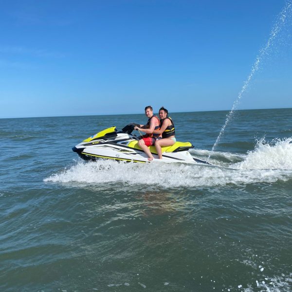 a man riding on the back of a boat in the water