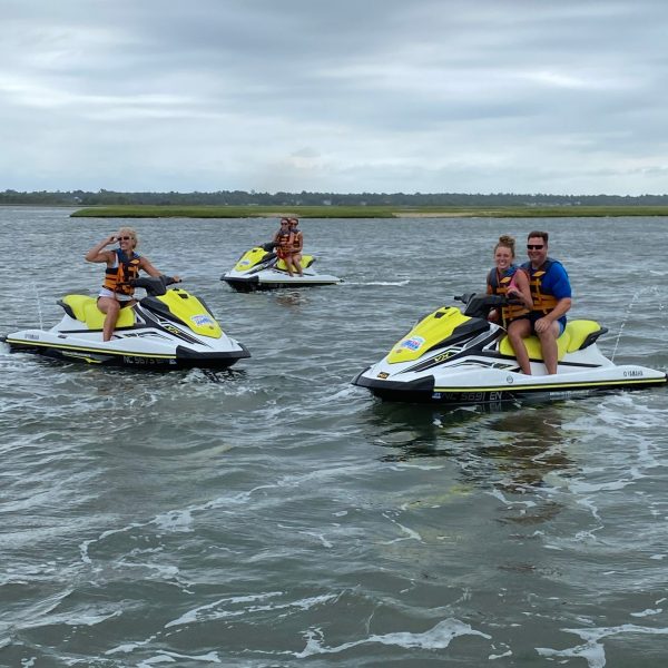 a group of people riding on the back of a boat in the water