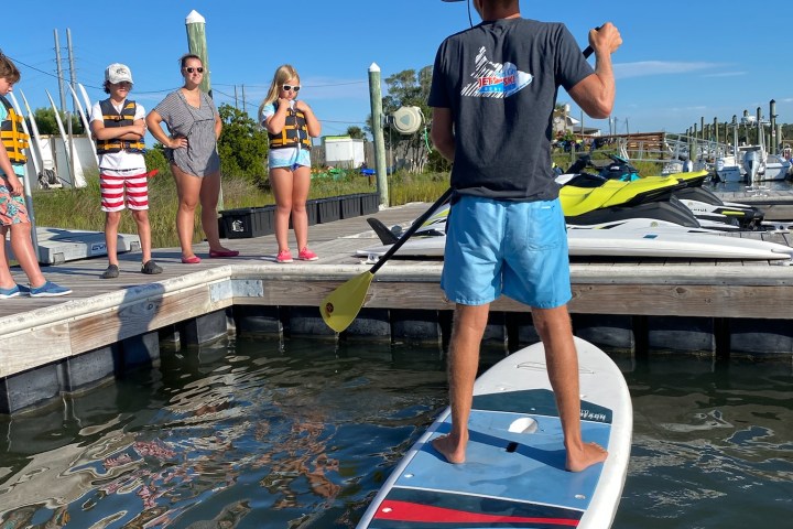 a group of people standing next to a body of water
