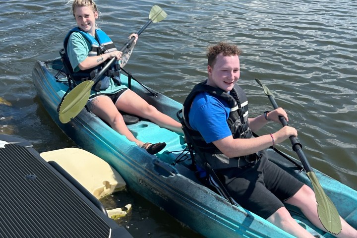 a group of people rowing a boat in the water