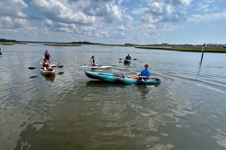 a group of people riding on the back of a boat in the water