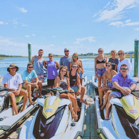 a group of people standing next to a body of water