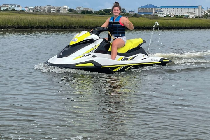 a man riding on the back of a boat in a body of water