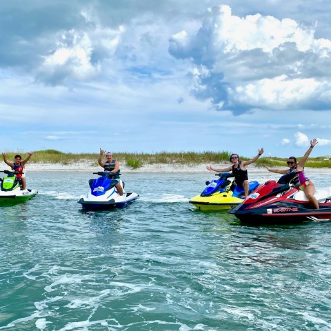 a group of people riding on the back of a boat in the water