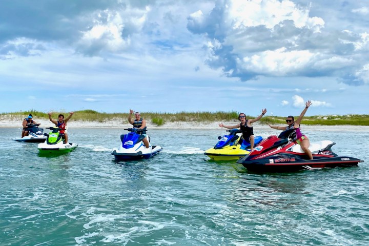 a group of people riding on the back of a boat in the water